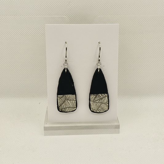 Handmade black polymer clay paddle drop earrings with botanical leaf print and stainless steel hooks on plain white card, by Crafty Larder NZ