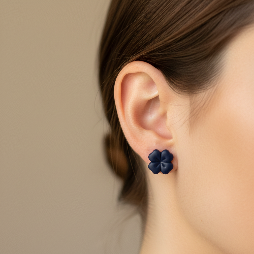 Woman wearing a Briar Stud in Crown Blue, deep inky navy polymer clay flower stud with minimal etched petal lines, handcrafted in New Zealand by Crafty Larder