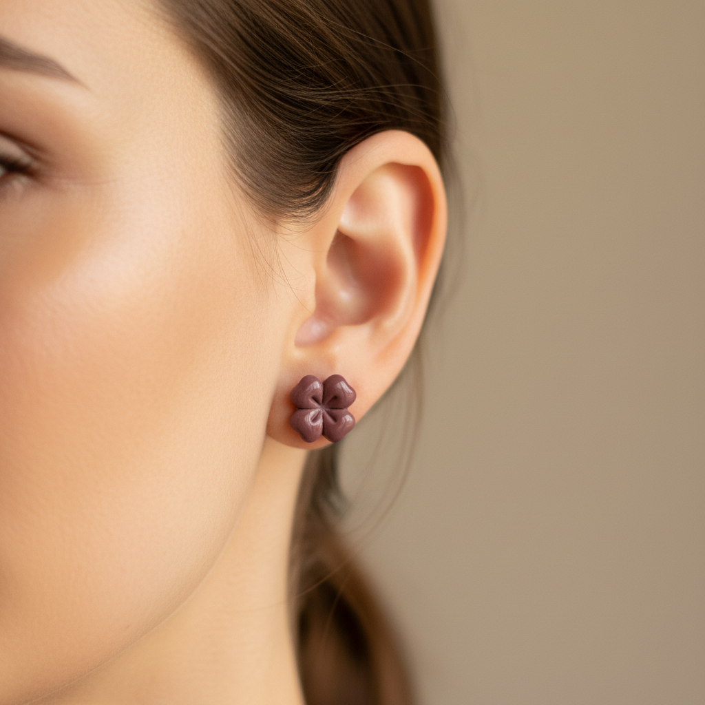 Woman wearing a Briar Stud in Damson, deep dusty plum purple polymer clay flower stud with minimal etched petal lines, handcrafted in New Zealand by Crafty Larder