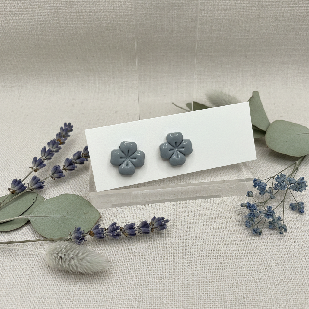 Briar Studs in Vapor Blue — handmade polymer clay 5-petal flower stud earrings with clean etched petal lines and glossy finish, displayed on white card with silvery dried lavender and dusty blue flower styling, handcrafted in New Zealand by Crafty Larder