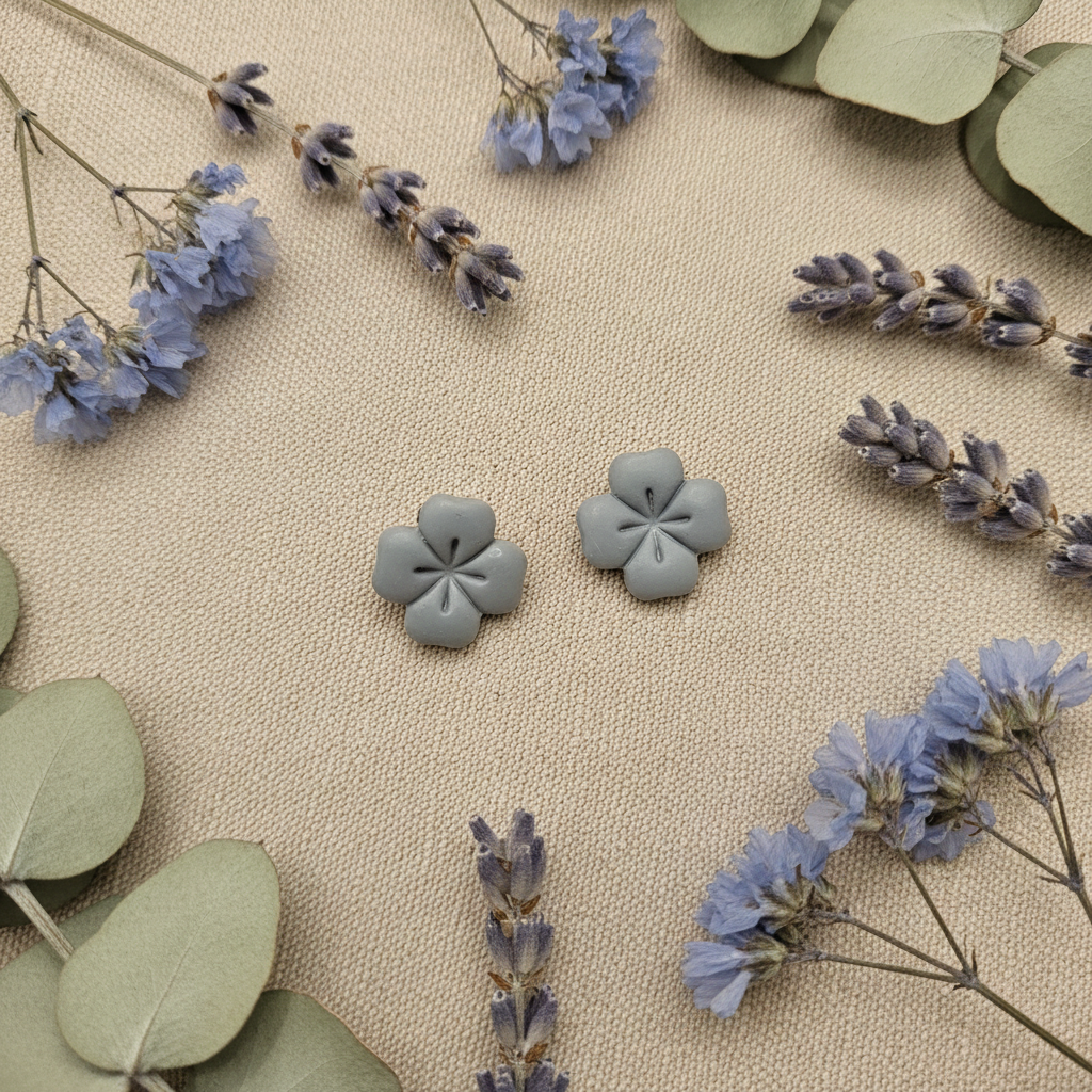 Briar Studs in Vapor Blue flat lay with silvery dried lavender and pale grey eucalyptus on warm linen, handmade polymer clay earrings from Crafty Larder's Harvest & Dusk Collection
