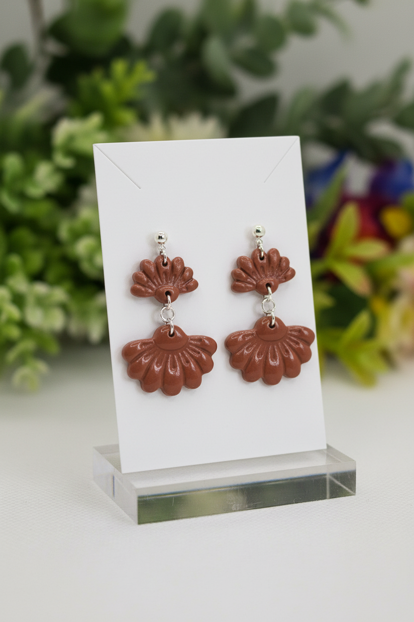 Handmade polymer clay Petal Tier Earrings in Chili Oil — warm terracotta brown two-tiered ruffled flower drops with silver ball stud, displayed on a plain white jewellery card with soft botanical background