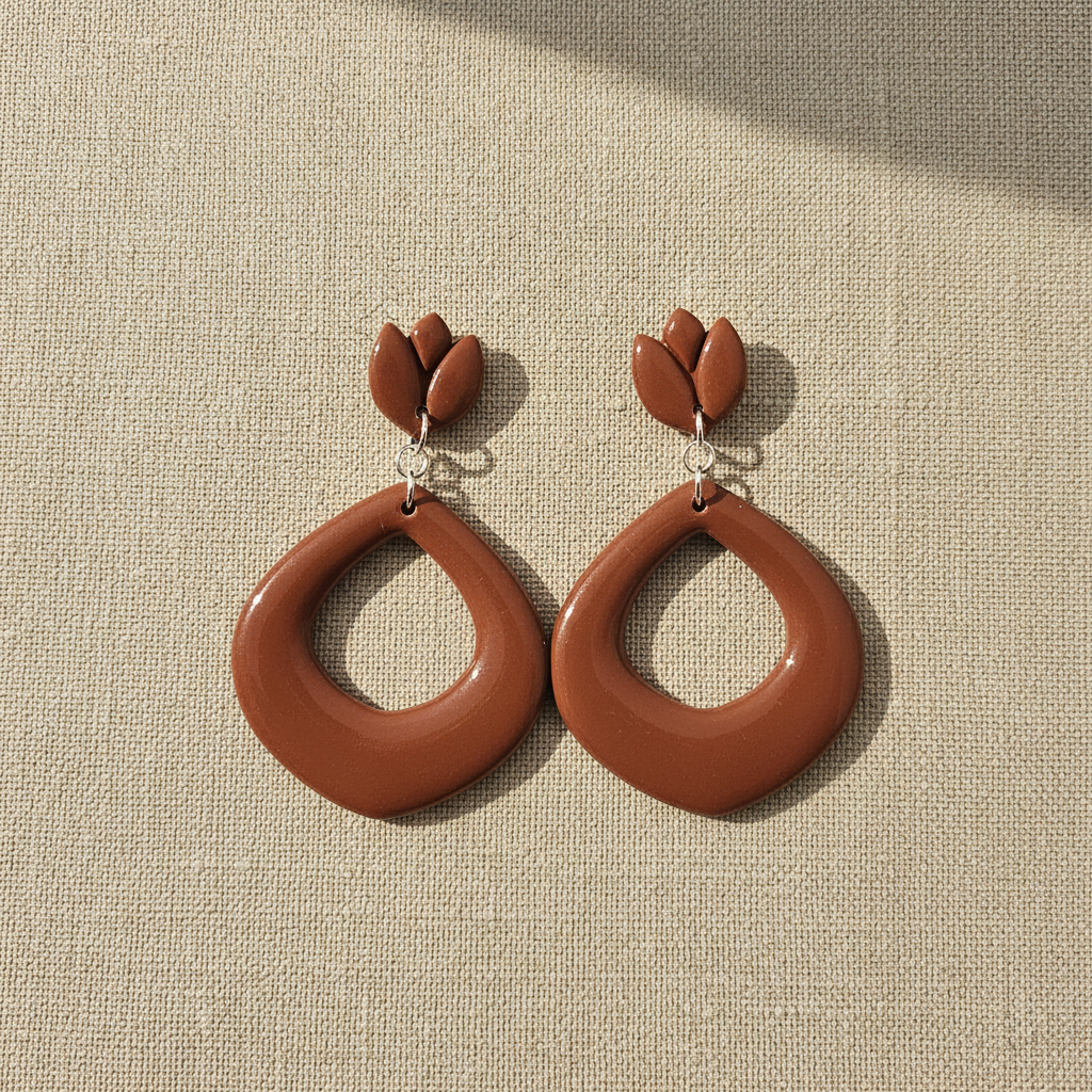 Flat lay of Crafty Larder Tulip Loop Earrings in Chili Oil on a natural linen surface — handmade polymer clay dangle earrings