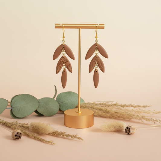 "Handmade polymer clay cocoa bean statement earrings with layered brown petals and embossed feather details"