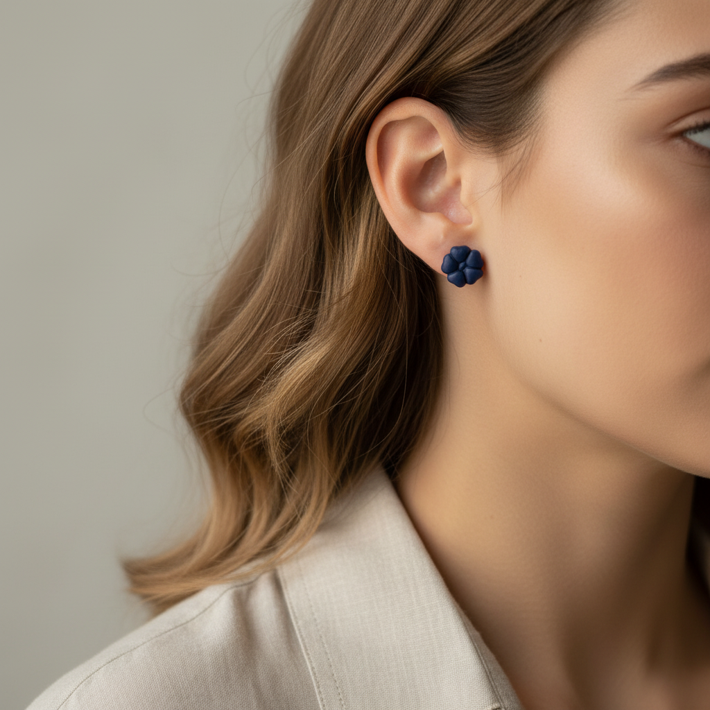 Woman wearing Blossom Studs in Crown Blue, deep navy blue polymer clay 5-petal flower studs, handcrafted in New Zealand by Crafty Larder