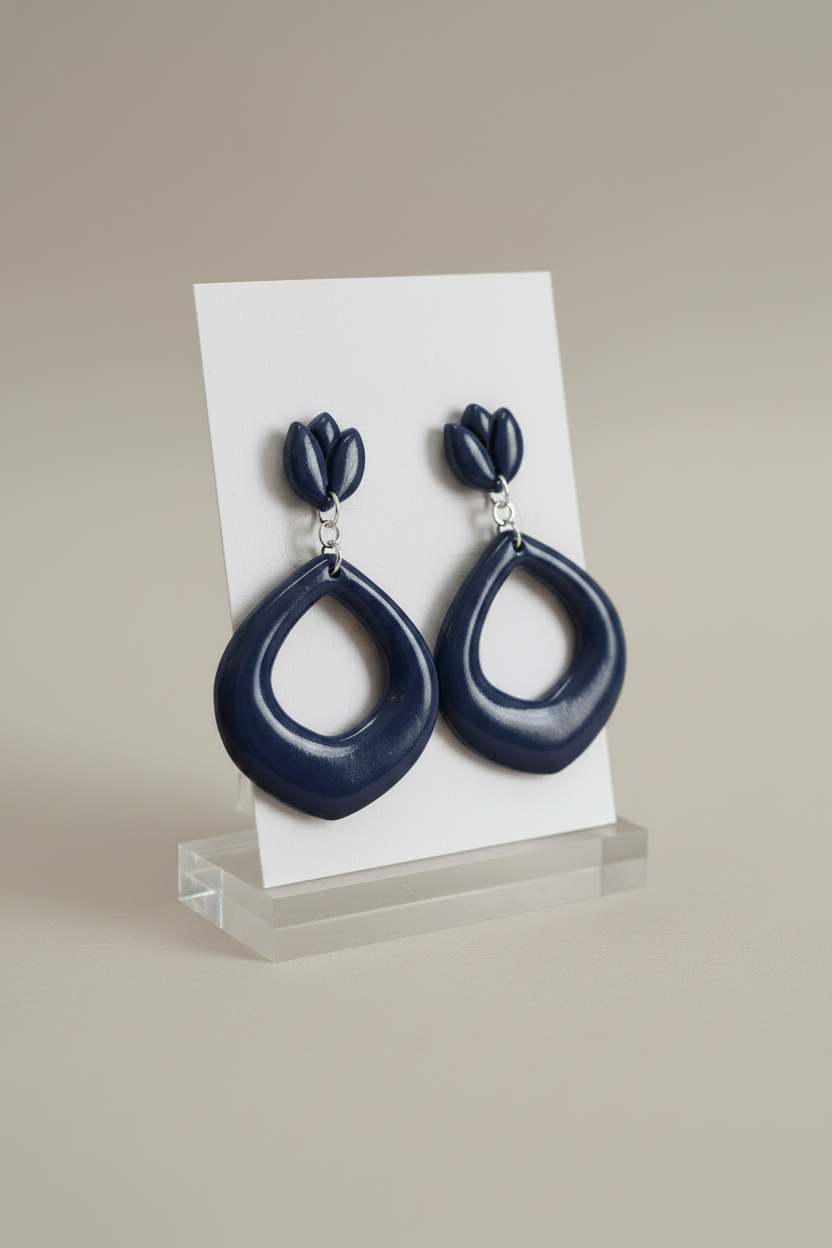 Handmade polymer clay Tulip Loop Earrings in Crown Blue — deep midnight navy tulip stud top with open teardrop hoop drop, displayed on a plain white jewellery card on a clear acrylic stand