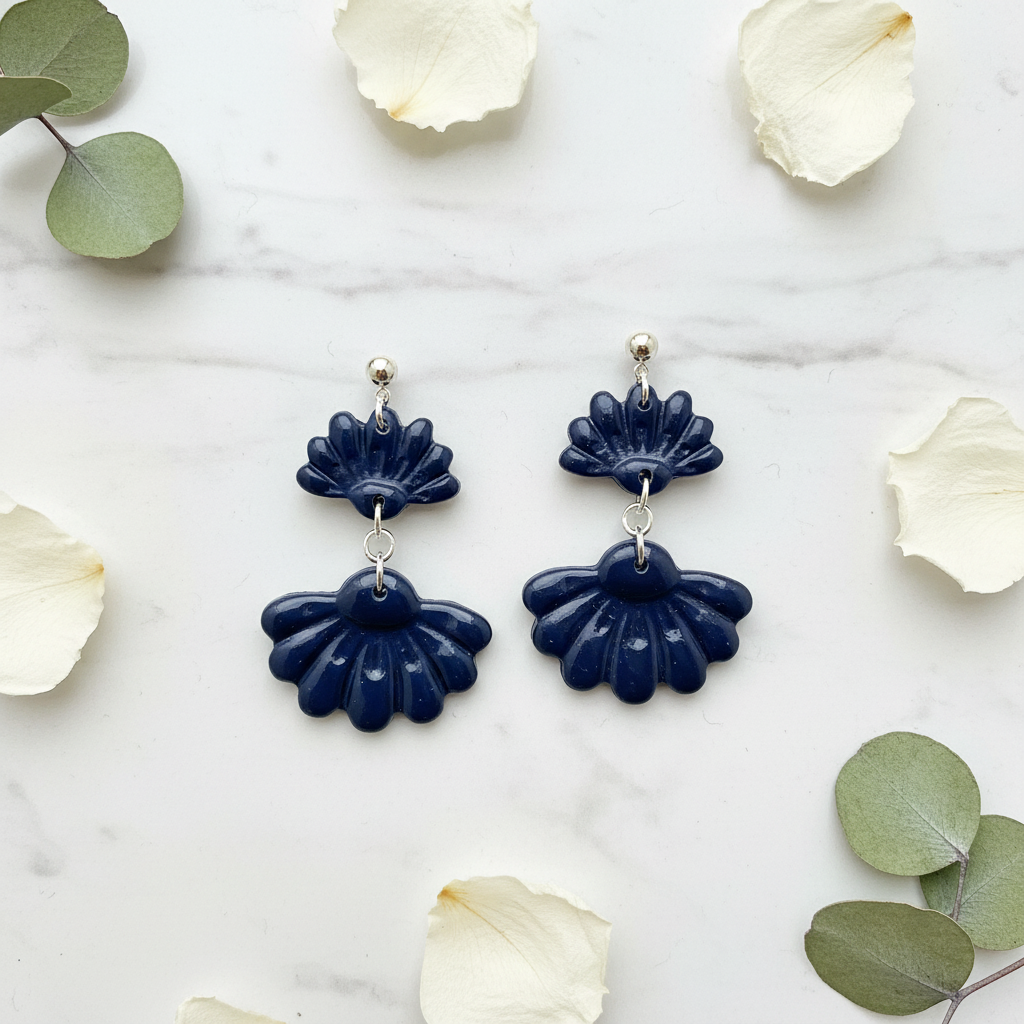 rown Blue on white marble with scattered petals — handmade polymer clay two-tiered ruffled drop earrings in deep midnight navy