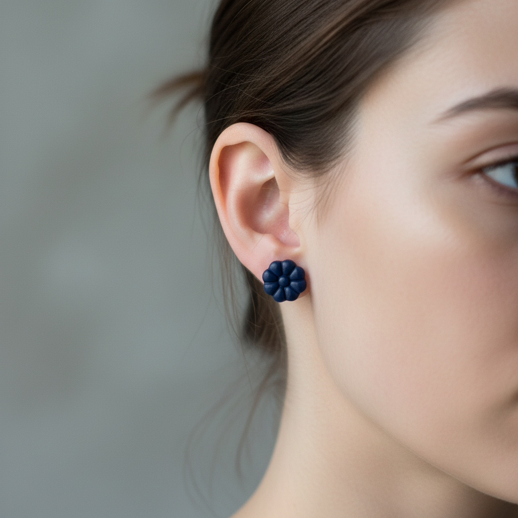 Woman wearing Dahlia Studs in Crown Blue, deep midnight navy blue polymer clay 8-petal dahlia flower studs, handcrafted in New Zealand by Crafty Larder