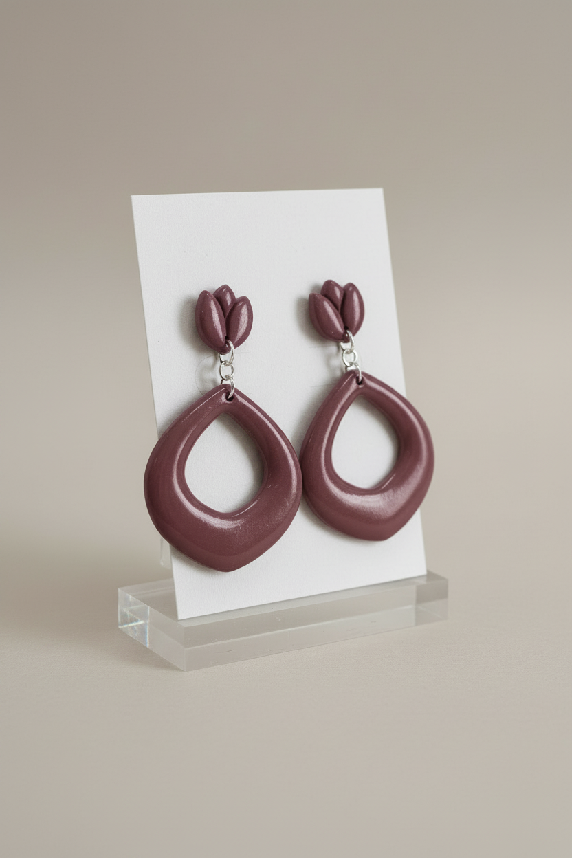 Handmade polymer clay Tulip Loop Earrings in Damson — muted dusty plum tulip stud top with open teardrop hoop drop, displayed on a plain white jewellery card on a clear acrylic stand