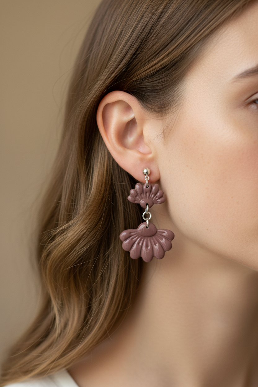 Close up of model wearing Crafty Larder Petal Tier Earrings in Damson — handmade polymer clay two-tiered ruffled drop earrings in muted dusty plum