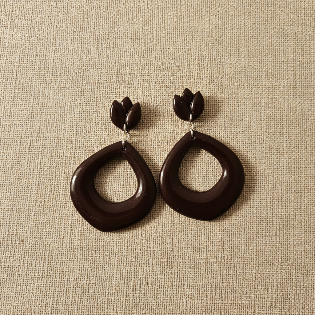 Flat lay of Crafty Larder Tulip Loop Earrings in French Roast on a natural linen surface — handmade polymer clay dangle earrings in deep espresso brown