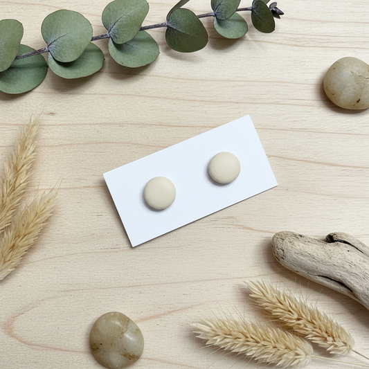 "Handmade polymer clay half cream stud earrings in soft beige matte finish"