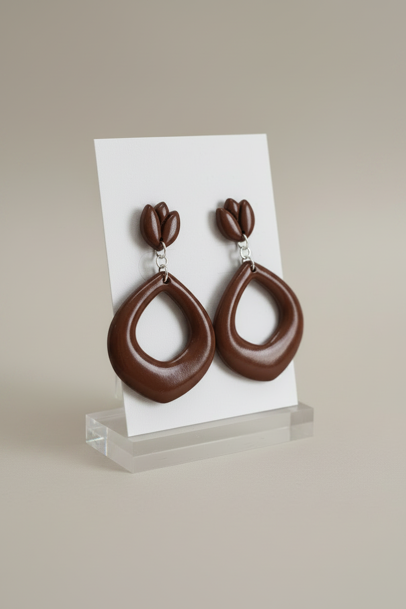 Handmade polymer clay Tulip Loop Earrings in Hot Chocolate — deep dark warm brown tulip stud top with open teardrop hoop drop, displayed on a plain white jewellery card on a clear acrylic stand