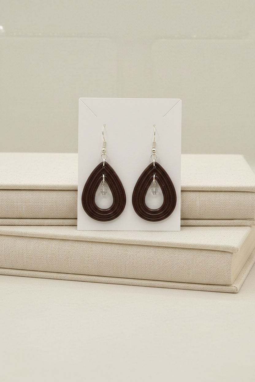 Handmade polymer clay Raindrop Crystal Earrings in Hot Chocolate — deep dark chocolate brown open teardrop hoop earrings with crystal bead drop, displayed on a plain white jewellery card propped against linen