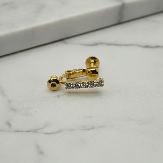 Close-up macro of 18k gold plated clip-on converter showing sparkling crystal rhinestones, on soft grey marble surface — Crafty Larder