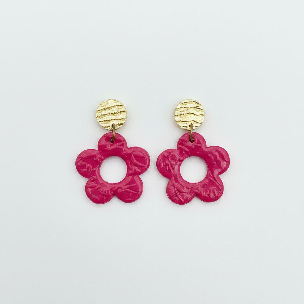 Handmade raspberry polymer clay open daisy drop earrings with gold textured brass stud tops, flat lay, by Crafty Larder NZ
