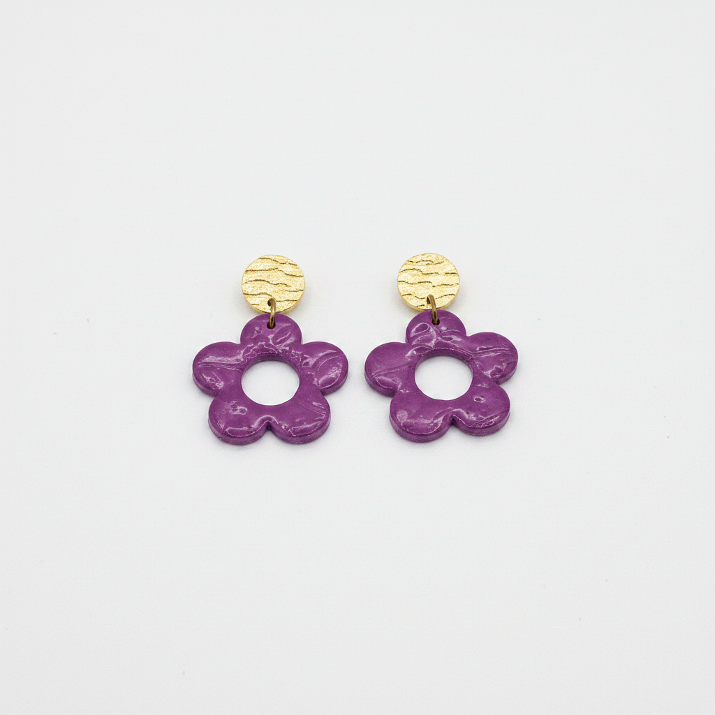 Handmade purple polymer clay open daisy drop earrings with gold textured brass stud tops, flat lay, by Crafty Larder NZ