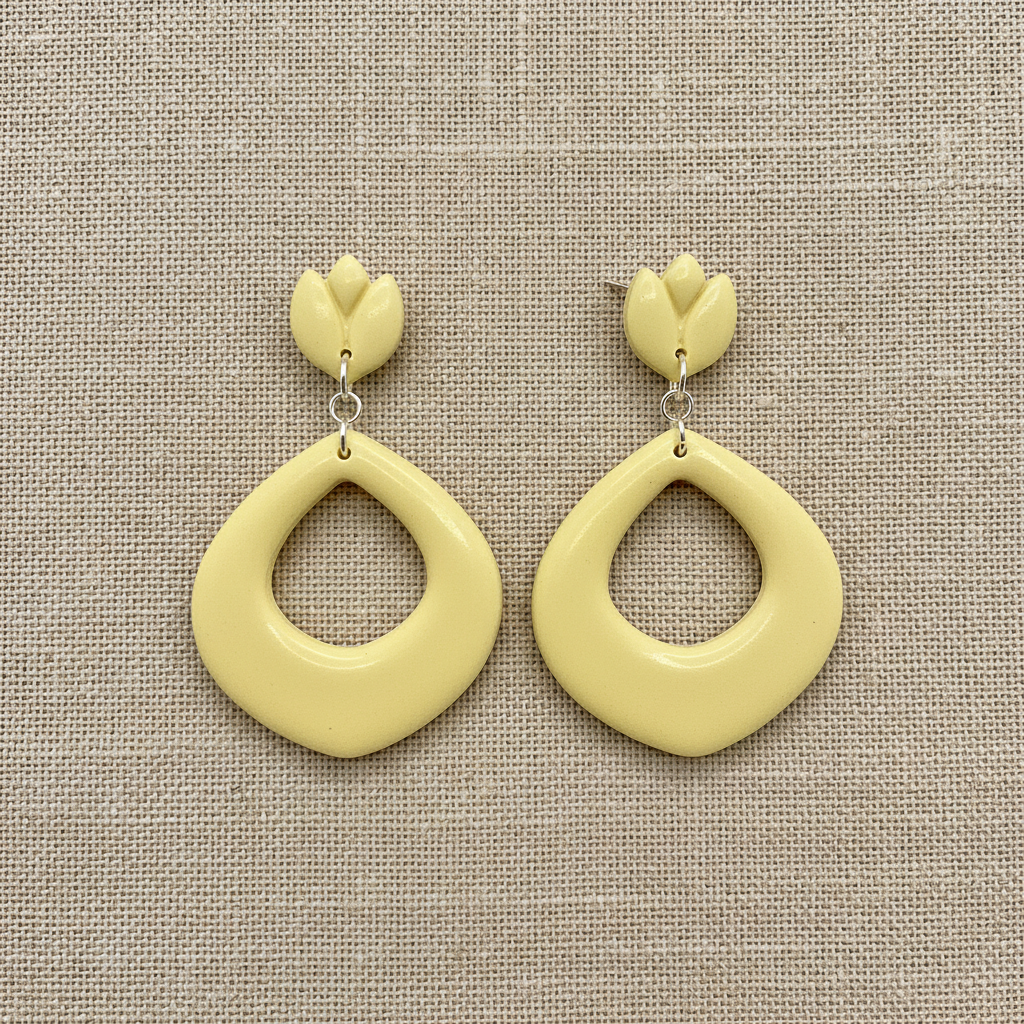 Flat lay of Crafty Larder Tulip Loop Earrings in Lemon Grass on a natural linen surface — handmade polymer clay dangle earrings in soft pale creamy yellow