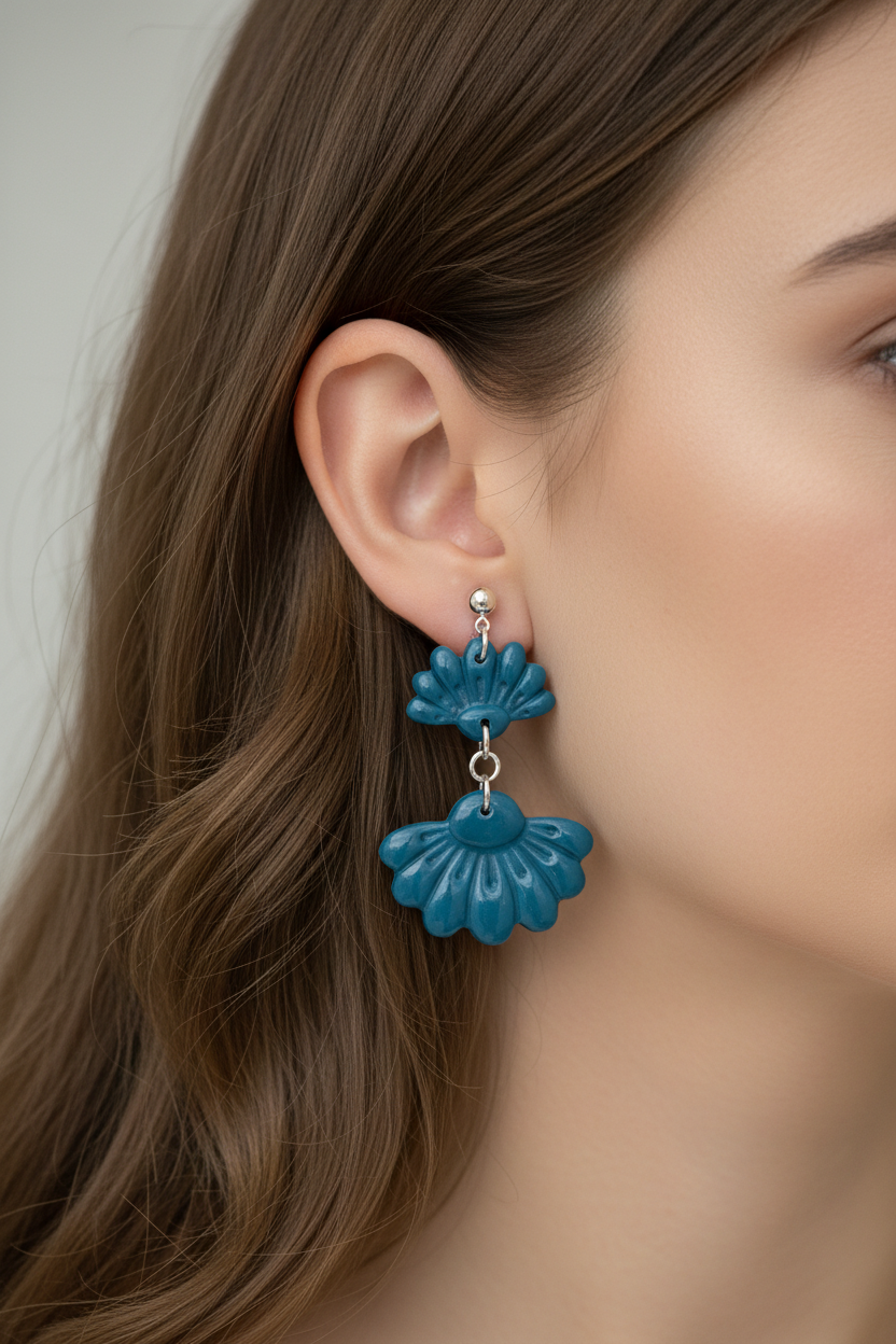 Close up of model wearing Crafty Larder Petal Tier Earrings in Lyons Blue — handmade polymer clay two-tiered fan-shaped ruffled drop earrings in teal-blue