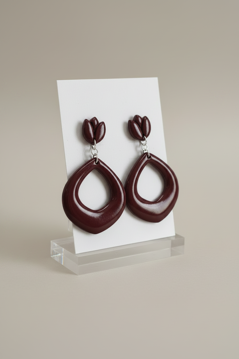 Handmade polymer clay Tulip Loop Earrings in Mauve Wine — deep dark burgundy tulip stud top with open teardrop hoop drop, displayed on a plain white jewellery card on a clear acrylic stand