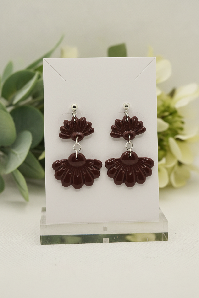 Handmade polymer clay Petal Tier Earrings in Mauve Wine — deep burgundy two-tiered ruffled flower drops with silver ball stud, displayed on a plain white jewellery card with soft botanical background