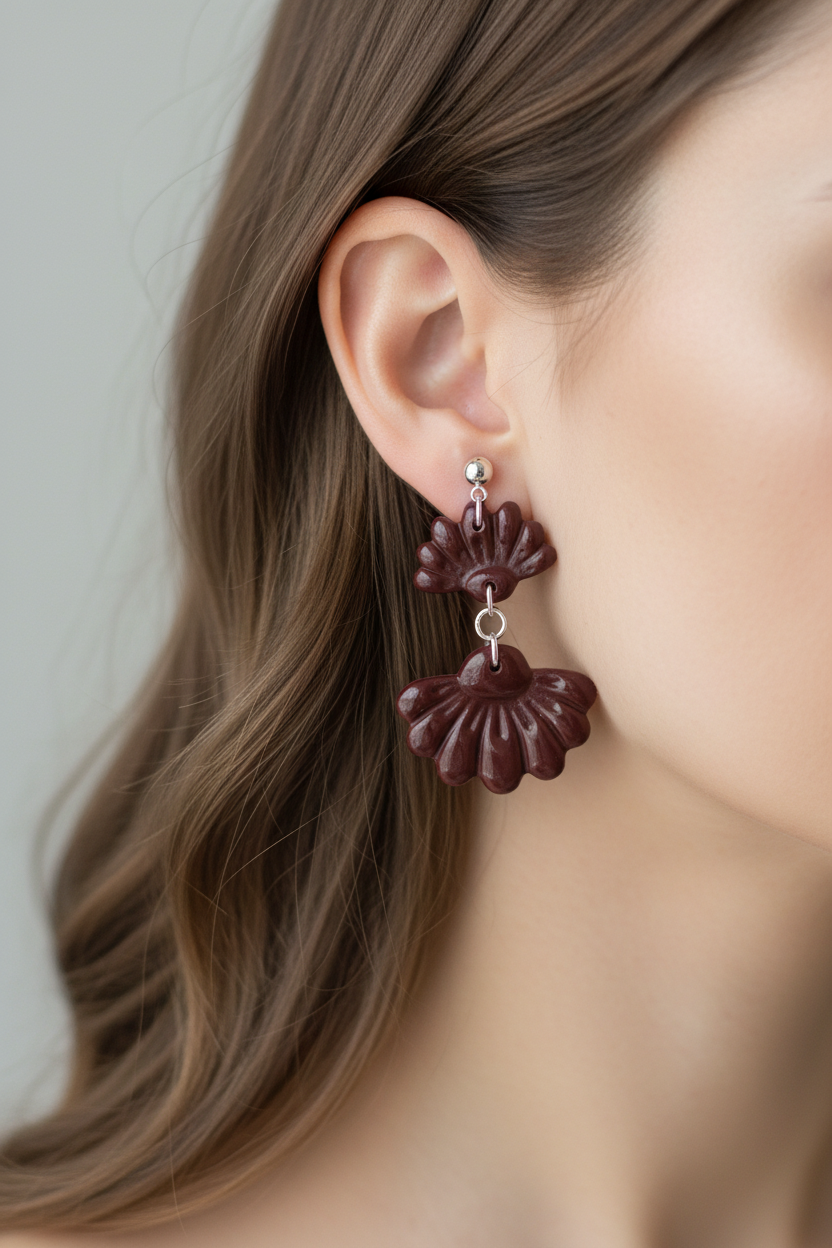 Close up of model wearing Crafty Larder Petal Tier Earrings in Mauve Wine — handmade polymer clay two-tiered ruffled drop earrings in deep burgundy