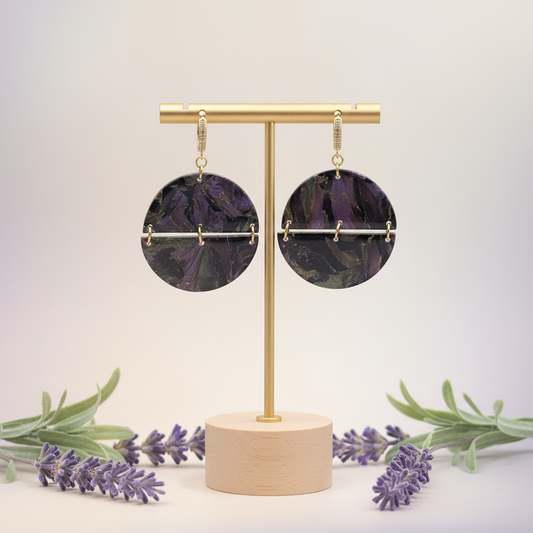  "Handmade polymer clay arc earrings with gold huggie hoop posts and large circular purple/black/green mica shimmer discs with gold arc bar across the middle"
