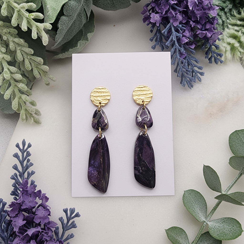 "Handmade polymer clay fob drop earrings with gold textured circular studs and purple/black mica shimmer teardrop dangles"