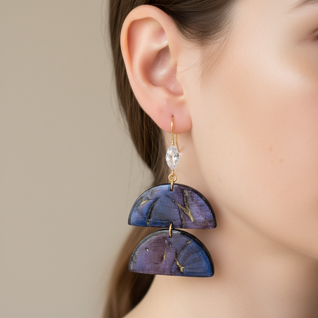"Handmade polymer clay two-tier half-moon earrings with gold shepherd hook ear wires featuring integrated cubic zirconia decoration and purple/blue mica shimmer half-moons"