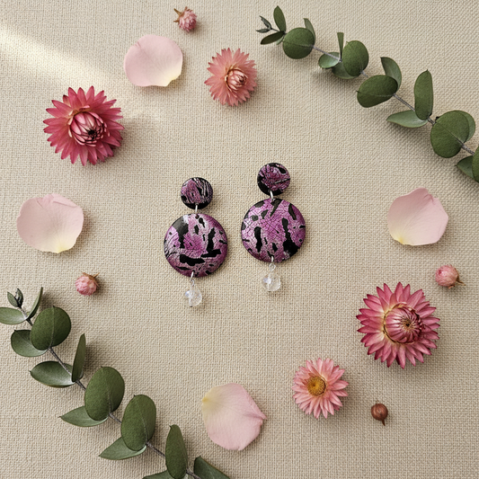 Pink Noir Statement Earrings displayed with flowers - handmade polymer clay tiered earrings with 3D floral design and crystal accent
