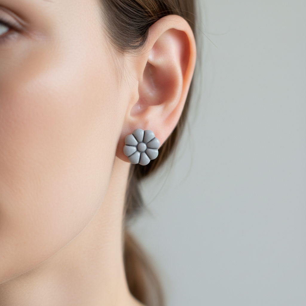 Woman wearing Dahlia Studs in Vapor Blue, soft misty grey-blue polymer clay 8-petal dahlia flower studs, handcrafted in New Zealand by Crafty Larder