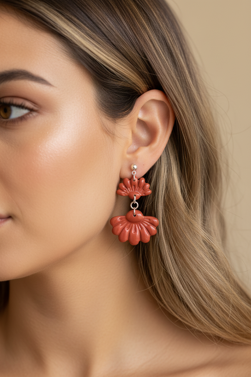 Close up of model wearing Crafty Larder Petal Tier Earrings in Winterberry — handmade polymer clay two-tiered ruffled drop earrings in warm terracotta red